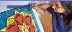 Kristen Palana painting a geometric mandala in bright blue, yellow, and red—closeup of art and artist’s hand.